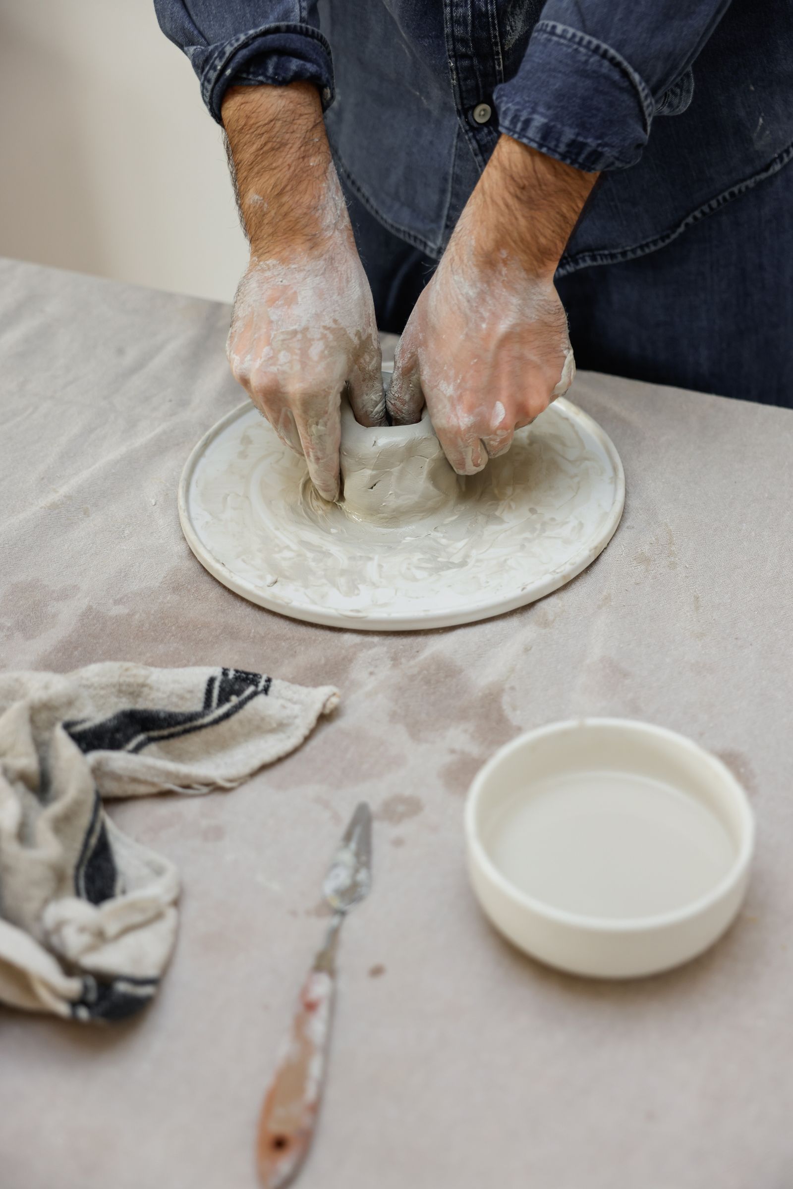 Des mains façonnant un bol en argile